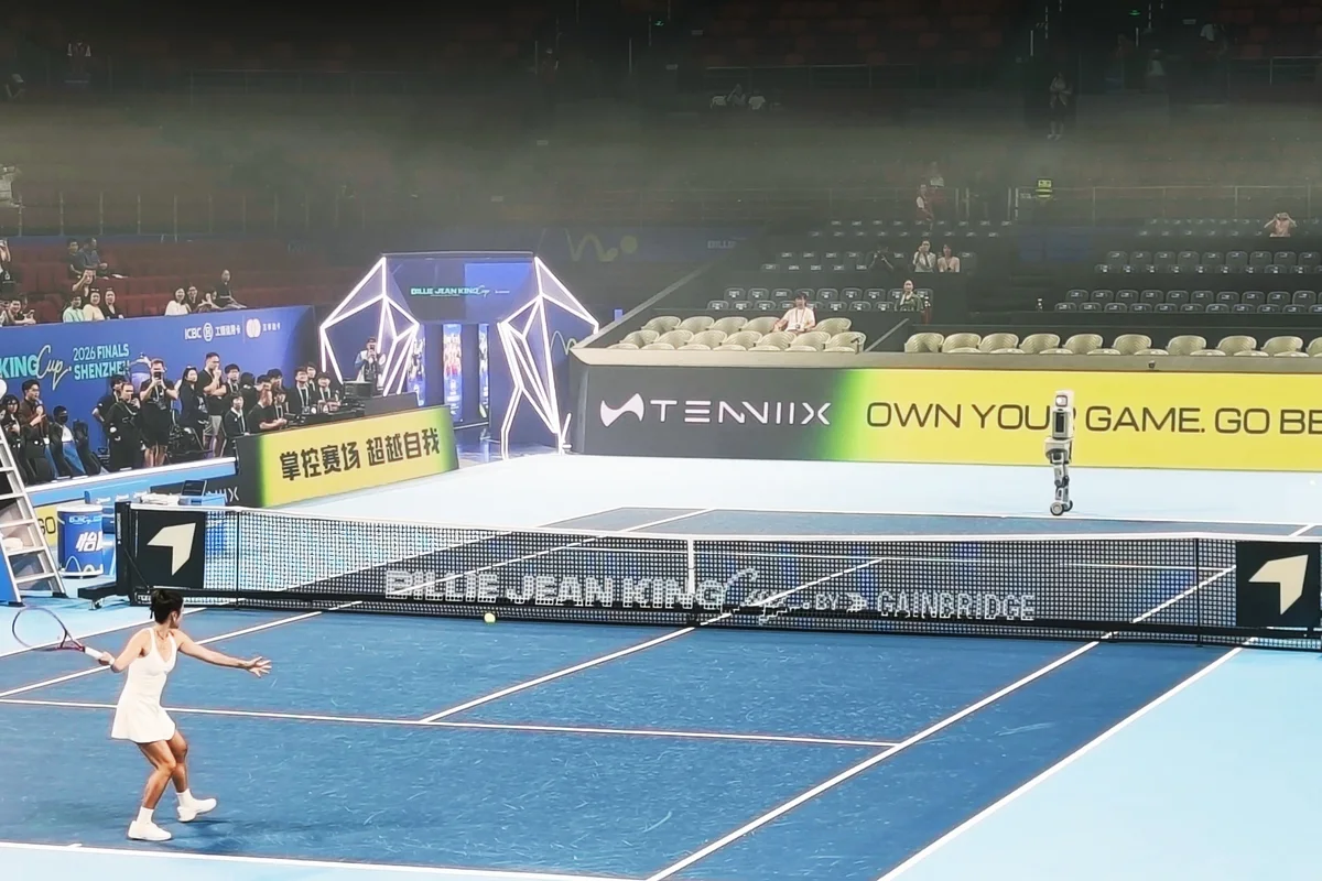 Wang Qiang and the TENNIIX tennis robot on opposite sides of the court